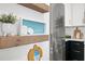 Bright kitchen featuring natural wood shelves, artwork and stainless steel appliances at 6250 Holmes Blvd # 63, Holmes Beach, FL 34217