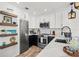 Modern kitchen featuring stainless steel appliances, quartz countertops, and dark blue lower cabinets at 6250 Holmes Blvd # 63, Holmes Beach, FL 34217