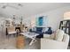 Open living room features a blue sofa, rattan chairs, and decor with access to the kitchen area at 6250 Holmes Blvd # 63, Holmes Beach, FL 34217