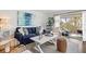 Inviting living room featuring a cozy blue sofa, stylish decor, and access to a bright, sunny balcony at 6250 Holmes Blvd # 63, Holmes Beach, FL 34217