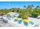 Charming outdoor seating area with colorful umbrellas and picnic tables, surrounded by lush greenery and palm trees at 6250 Holmes Blvd # 63, Holmes Beach, FL 34217