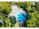 Aerial view of a fenced community pool surrounded by trees and lounge chairs at 6250 Holmes Blvd # 63, Holmes Beach, FL 34217