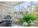 Relaxing screened porch with comfortable seating and outdoor dining area with a view of tropical landscaping at 6250 Holmes Blvd # 63, Holmes Beach, FL 34217
