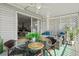 Outdoor porch with a dining table, seating area, and lush landscaping, showcasing the indoor/outdoor living space at 6250 Holmes Blvd # 63, Holmes Beach, FL 34217
