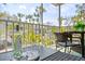 Tranquil screened porch featuring comfortable seating and a table set for wine, inviting relaxation amidst lush landscaping at 6250 Holmes Blvd # 63, Holmes Beach, FL 34217