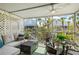 Cozy screened porch with comfortable seating, outdoor dining, and views of surrounding tropical landscaping at 6250 Holmes Blvd # 63, Holmes Beach, FL 34217