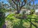 Landscaped backyard featuring mature trees and lush lawn surrounding a charming home at 6402 23Rd Avenue W Dr, Bradenton, FL 34209
