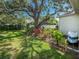 Serene backyard with lush landscaping, mature trees, and a glimpse of the home's exterior at 6402 23Rd Avenue W Dr, Bradenton, FL 34209