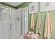 Bright bathroom featuring a glass-enclosed shower, shuttered window, and decorative wall art and towel arrangement at 6402 23Rd Avenue W Dr, Bradenton, FL 34209