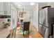 Bright breakfast nook features a glass table, unique lighting, and stainless steel refrigerator at 6402 23Rd Avenue W Dr, Bradenton, FL 34209