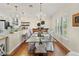 Elegant dining area with a modern chandelier, glass-top table, and beautiful hardwood floors at 6402 23Rd Avenue W Dr, Bradenton, FL 34209