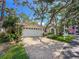 Charming single-story home with paved driveway, mature trees, attached garage, and lush landscaping at 6402 23Rd Avenue W Dr, Bradenton, FL 34209