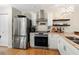 Well-lit kitchen featuring stainless steel appliances, custom cabinets, and hardwood floors at 6402 23Rd Avenue W Dr, Bradenton, FL 34209