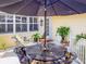 Outdoor seating area with a large umbrella, surrounded by potted plants and a tranquil ambiance at 6402 23Rd Avenue W Dr, Bradenton, FL 34209
