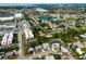 Scenic aerial view of a residential neighborhood featuring tree-lined streets, a lake, and a mix of commercial and residential properties at 6442 Colonial Dr, Sarasota, FL 34231