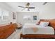 Sunlit bedroom with wood frame bed, ceiling fan, and a decorative chest of drawers at 6442 Colonial Dr, Sarasota, FL 34231