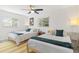 Bright bedroom with two twin beds, ceiling fan, and sunny windows at 6442 Colonial Dr, Sarasota, FL 34231