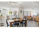 Open-concept dining room with a rustic table, flowing into the bright living area and kitchen at 6442 Colonial Dr, Sarasota, FL 34231