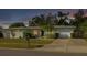 Charming single-story home with a well-manicured lawn and mature landscaping at dusk at 6442 Colonial Dr, Sarasota, FL 34231