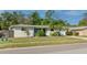 Charming single-Gathering home featuring a well-manicured lawn, mature landscaping, and a driveway leading to a garage at 6442 Colonial Dr, Sarasota, FL 34231