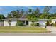 Inviting single-story home boasting a lush front yard with palm trees, mature foliage, and an attached garage at 6442 Colonial Dr, Sarasota, FL 34231