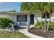 Inviting front porch with seating area, palm trees, and landscaping, enhancing the curb appeal of this charming residence at 6442 Colonial Dr, Sarasota, FL 34231