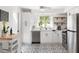 Bright kitchen featuring white cabinetry, stainless steel appliances, patterned tile flooring, and a window with a lovely outdoor view at 6442 Colonial Dr, Sarasota, FL 34231