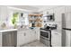 Modern kitchen with stainless steel appliances, white cabinets, and stylish backsplash at 6442 Colonial Dr, Sarasota, FL 34231
