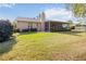 Exterior view of home showing the back lawn and screened porch at 6675 Easton Dr, Sarasota, FL 34238