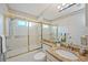 Bathroom featuring granite countertop vanity, neutral color scheme, and a glass-enclosed shower/tub combination at 6675 Easton Dr, Sarasota, FL 34238