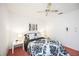 Cozy bedroom with a queen bed, patterned bedding, soft lighting and a window with sheer curtains at 6675 Easton Dr, Sarasota, FL 34238