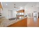 Open kitchen layout showcasing granite countertops, wooden cabinets, and connection to the dining and living spaces at 6675 Easton Dr, Sarasota, FL 34238