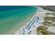 Coastal view featuring clear turquoise waters meeting the sandy beach dotted with beach chairs and umbrellas at 6836 Midnight Pass Rd # 6836, Sarasota, FL 34242