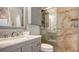 Elegant bathroom featuring a marble countertop, gray cabinetry, and a glass-enclosed shower with tiled walls at 6836 Midnight Pass Rd # 6836, Sarasota, FL 34242