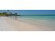 Scenic beach view with clear turquoise waters, white sand, and people enjoying the water and shoreline at 6836 Midnight Pass Rd # 6836, Sarasota, FL 34242