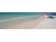 Scenic beach view with clear turquoise waters meeting the sandy shore filled with people at 6836 Midnight Pass Rd # 6836, Sarasota, FL 34242
