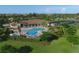 Aerial view of a community pool, clubhouse, and courts surrounded by lush landscaping at 6907 Grand Estuary Trl # 104, Bradenton, FL 34212