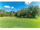 Expansive backyard featuring lush green grass and trees at 6907 Grand Estuary Trl # 104, Bradenton, FL 34212