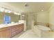 This bathroom features double sinks with a separate tub and a glass enclosed shower at 6907 Grand Estuary Trl # 104, Bradenton, FL 34212