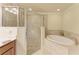 Bright bathroom featuring a glass enclosed shower and a soaking tub with tile surround at 6907 Grand Estuary Trl # 104, Bradenton, FL 34212
