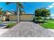 Exterior shot featuring a well-maintained brick driveway and lush landscaping at 6907 Grand Estuary Trl # 104, Bradenton, FL 34212