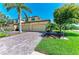 Front exterior showcasing a three-car garage and a brick driveway at 6907 Grand Estuary Trl # 104, Bradenton, FL 34212