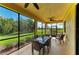 This beautiful screened-in lanai features a dining table and ceiling fans at 6907 Grand Estuary Trl # 104, Bradenton, FL 34212