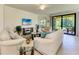 Comfortable living room with tile floors, neutral decor, and a view of the screened-in patio at 6907 Grand Estuary Trl # 104, Bradenton, FL 34212