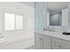Elegant bathroom with a tiled tub, modern vanity, and striking blue leaf-patterned wallpaper at 6909 34Th W Ave, Bradenton, FL 34209