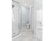 Modern bathroom featuring a glass-enclosed shower, toilet, and tub with sleek, light blue walls at 6909 34Th W Ave, Bradenton, FL 34209