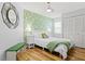 Charming bedroom with palm leaf wallpaper, white furnishings, and warm wood flooring at 6909 34Th W Ave, Bradenton, FL 34209
