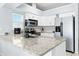 Kitchen with stainless steel appliances, white cabinetry and stone countertops at 6909 34Th W Ave, Bradenton, FL 34209