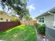 Backyard lawn features a wood fence for privacy and mature landscaping at 708 32Nd W St, Bradenton, FL 34205