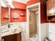 Red-walled bathroom featuring a granite vanity and a glass shower at 708 32Nd W St, Bradenton, FL 34205